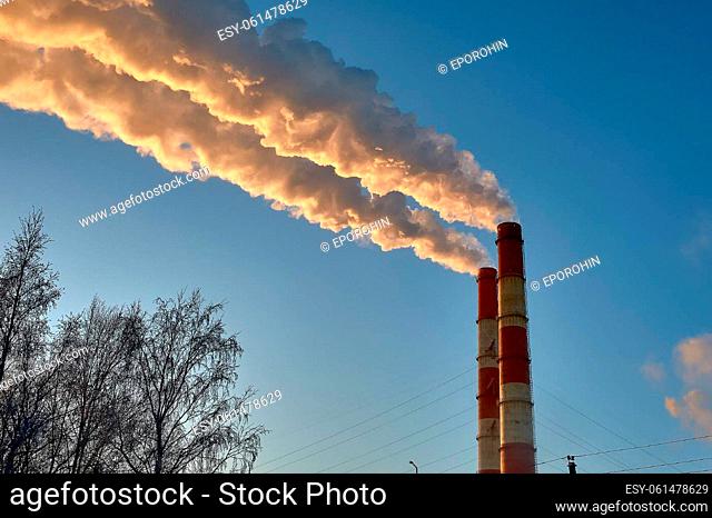 white smoke is coming out of the pipes in the blue sky. High quality photo
