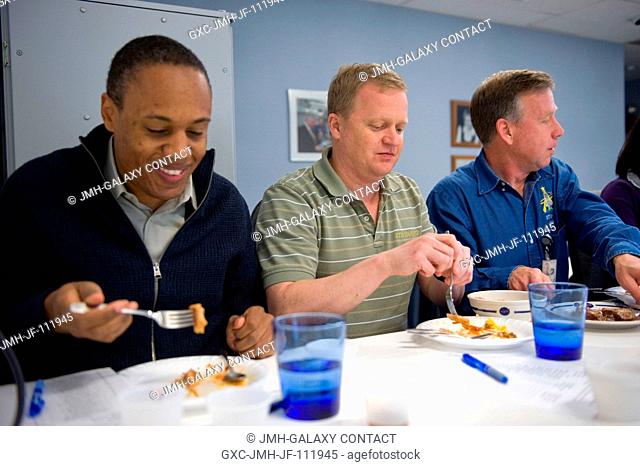NASA astronauts Steve Lindsey (right), STS-133 commander; Eric Boe (center), pilot; and Alvin Drew, mission specialist, are pictured during a food tasting...