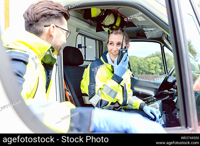 Paramedics in ambulance in radio contact with headquarters discussion deployment