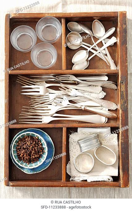 An old drawer with forks, spoons, napkin rings and cloves