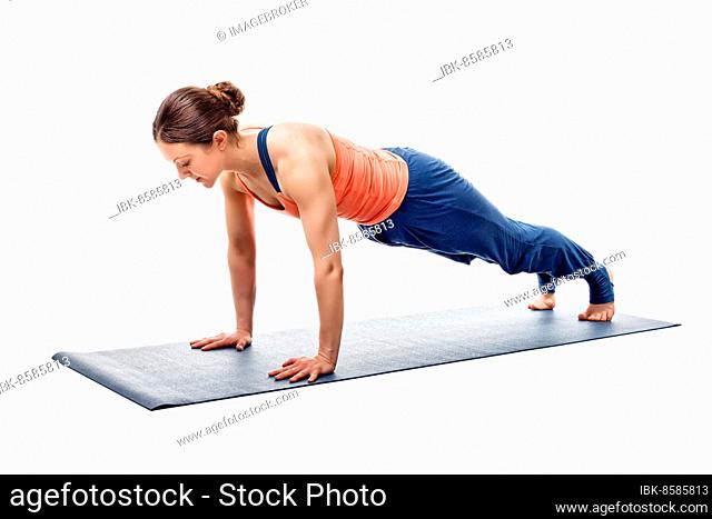 Young fit sporty woman doing Hatha yoga asana Utthita chaturanga dandasana, extended four-limbed staff (plank) pose isolated