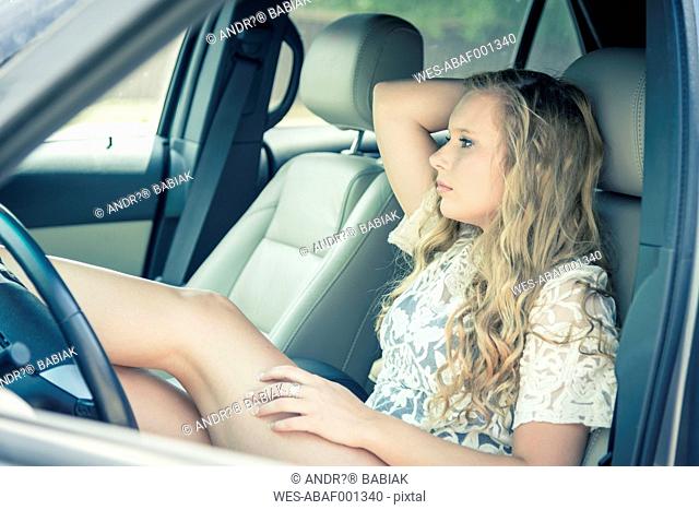 Young woman sitting in car watching something