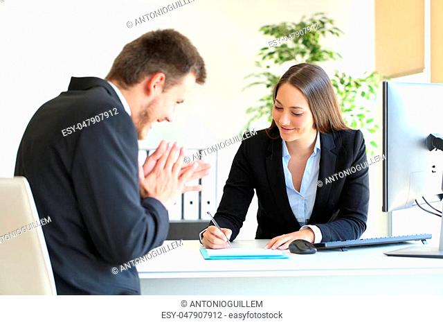 Businesspeople wearing suit signing contract after a successful deal at office