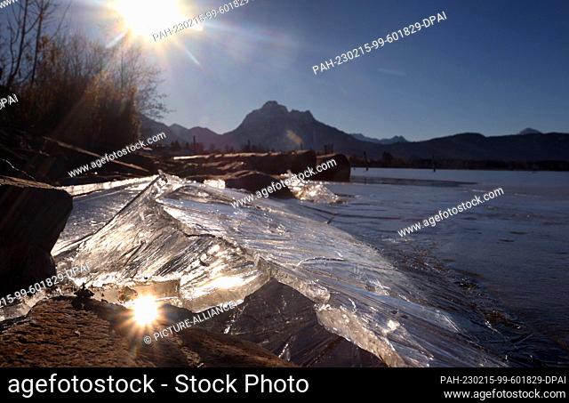 15 February 2023, Bavaria, Füssen: Ice thaws in the sunshine on the shore of the Hopfensee lake on the edge of the Alps. Photo: Karl-Josef Hildenbrand/dpa