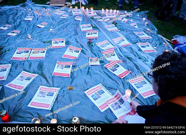 12 October 2023, Berlin: People lay on the ground sheets of paper with missing persons notices of people who have fallen victim to the Hamas attack in Israel