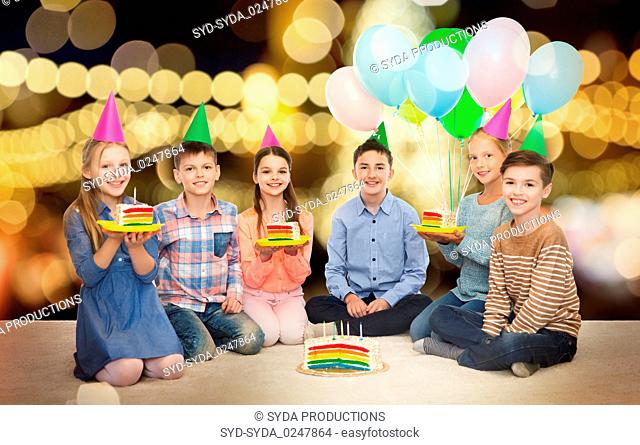 happy children in party hats with birthday cake