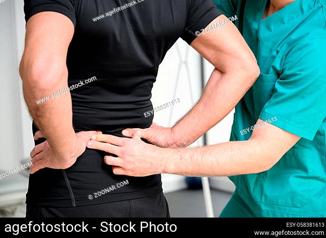 Rear view of a physiotherapist examining man back. High quality photo