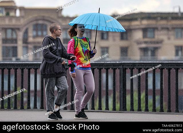 RUSSIA, MOSCOW - JULY 23, 2023: Two women walk under an umbrella along the Krymsky Bridge. Sofya Sandurskaya/TASS