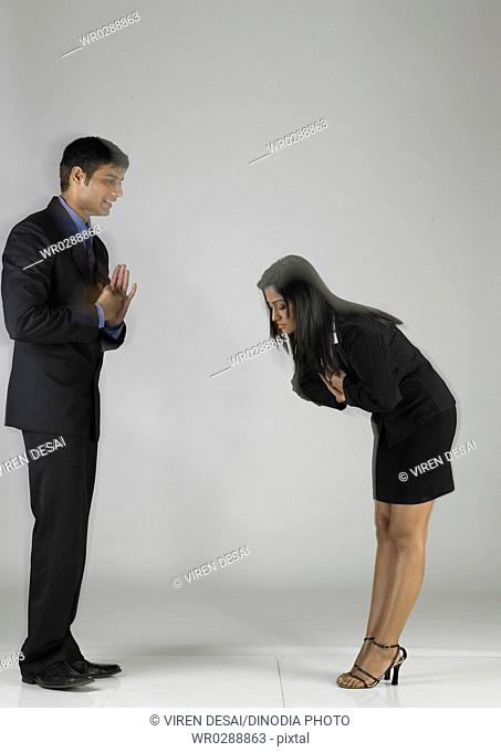 South Asian Indian executive woman bend down in front of man MR