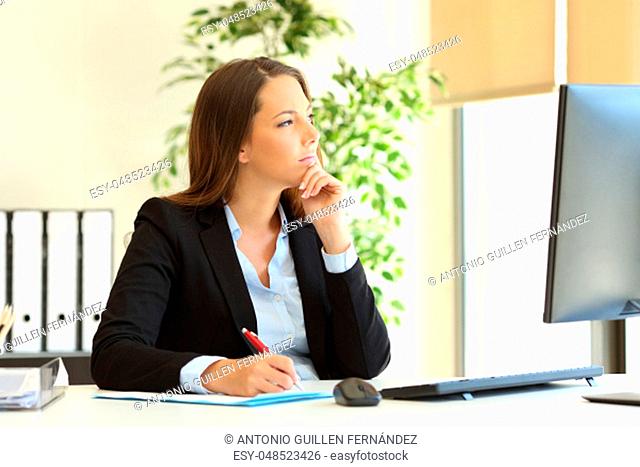 Pensive office worker looks away through a window at workplace