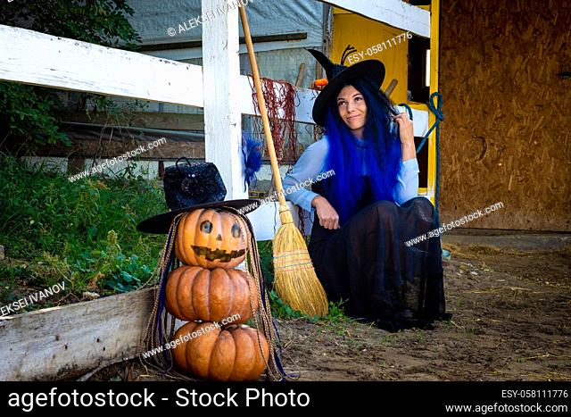 Halloween celebration witch and pumpkin figure sit by the fence