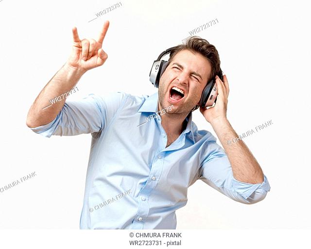 adult, audio, beat, blue, Caucasian, earphones, enjoy, entertainment, excited, expression, face, fun, guy, happy, headphone, headphones, hear, isolated, leisure