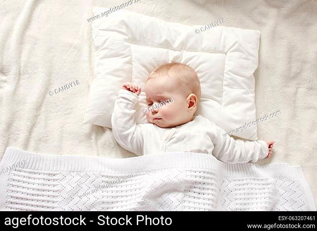Cute five month old baby sleeping in comfortable bed. Concept of the family andparenting