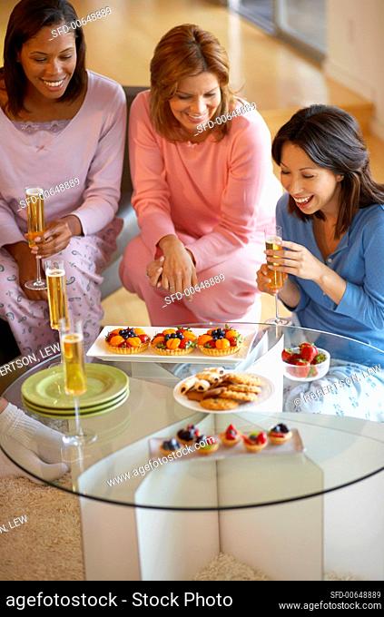 Women chatting with sparkling wine and fruit tarts