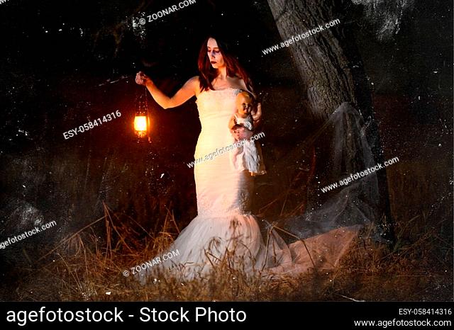 Scary woman with a lantern in night scene - Spooky image of a scary woman with dark eyes and appearance of a witch, in a white dress