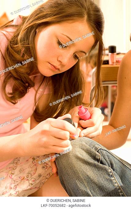 Teenage girls (14-16) painting their nails