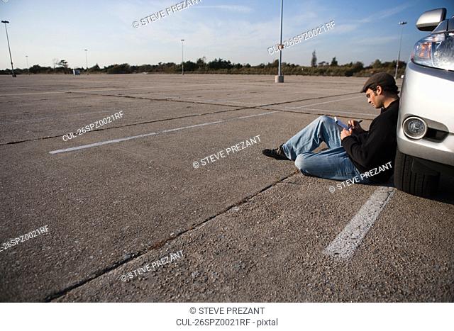 Man writing in parking lot