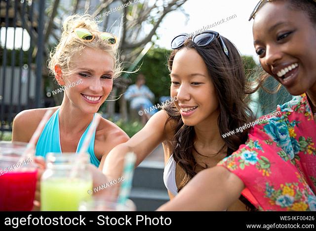 Happy multiracial friends having fresh juice
