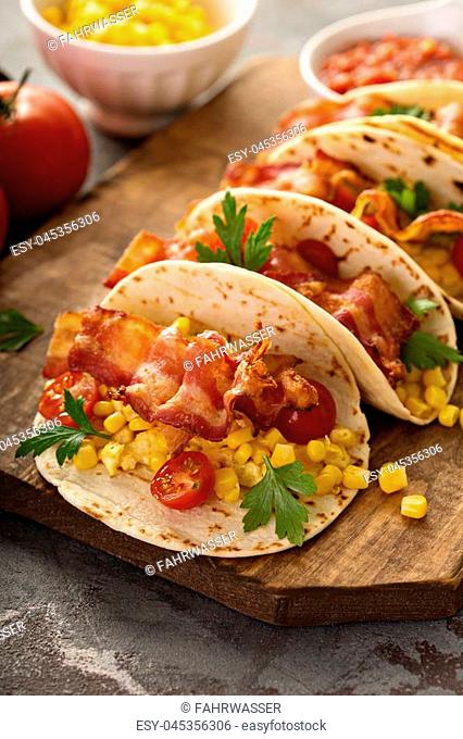 Breakfast tacos with scrambled eggs, corn, tomatoes and bacon