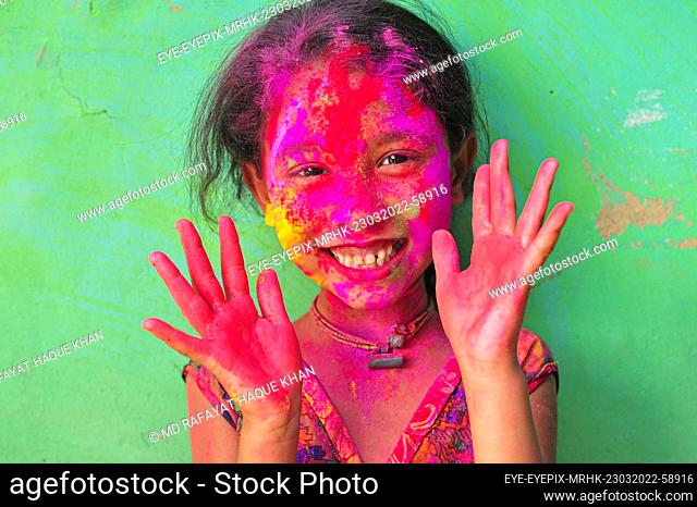 SYLHET, BANGLADESH - MARCH 23, 2022: Bangladesh children from Khan Tea garden posing for photos painted after adorning with colors like Rainbows on the...