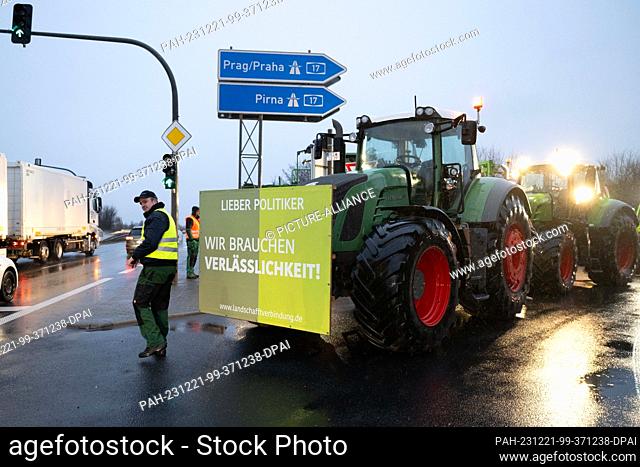 21 December 2023, Saxony, Dresden: Farmers with tractors block a highway access road to Autobahn 17 in protest against the planned abolition of tax breaks by...