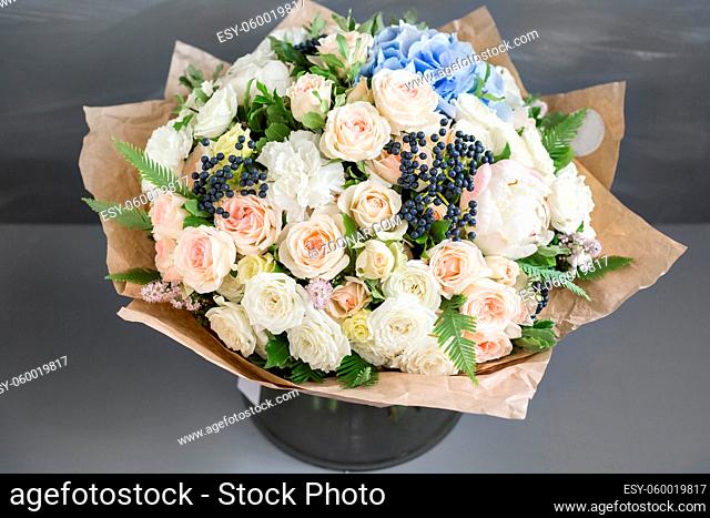 Rich bunch of peonies, roses and blue hydrangea flowers, green leaf. Fresh spring bouquet. Summer Background. Selective focus