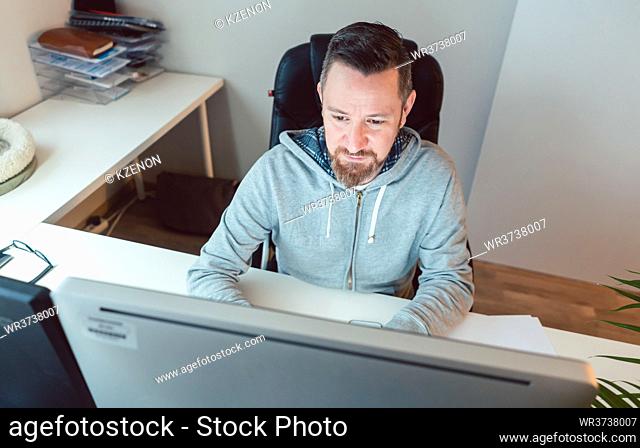 Young man in advertising agency designing project on computer