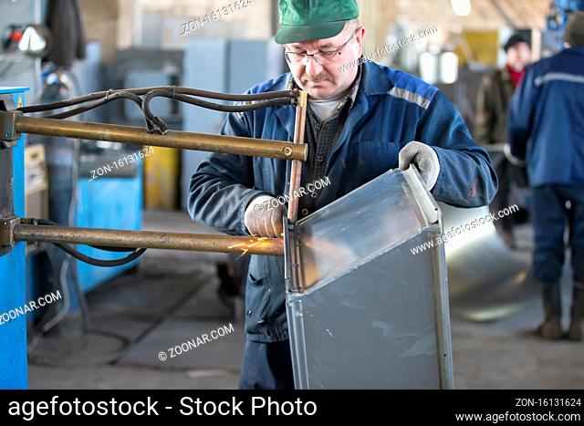 Belarus, the city of Gomel, April 30, 2019. Ventilation plant. Manufacturing of ventilation metal pipes. Worker makes ventilation pipes