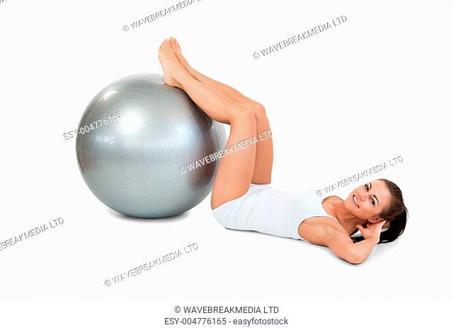 Young woman developing her abs with a ball