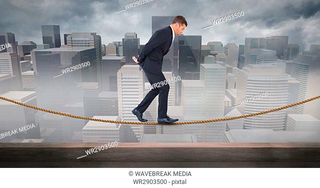 Digital composite image of businessman walking on rope against cityscape