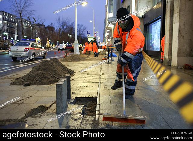 RUSSIA, MOSCOW - DECEMBER 18, 2023: A utility worker carries out block paving maintenance in Tverskoy Boulevard. Mikhail Tereshchenko/TASS