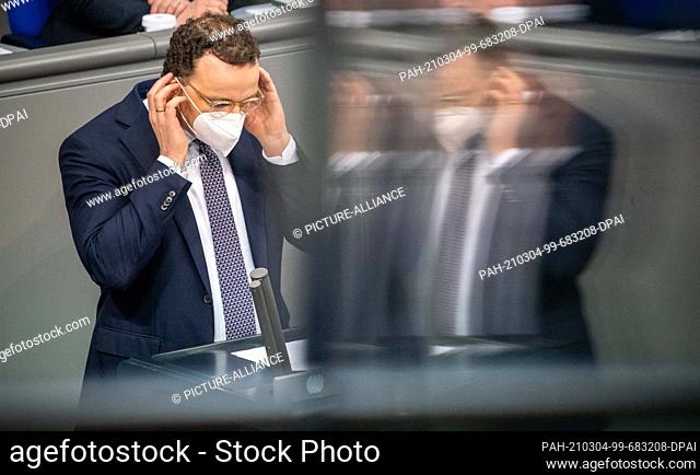 04 March 2021, Berlin: Jens Spahn (CDU), Federal Minister of Health, puts on his mask after speaking in plenary session in the German Bundestag