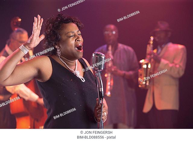 Black woman singing on stage with jazz band