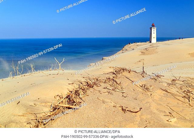 23 April 2019, Denmark, Lönstrup: The lighthouse Rubjerg Knude on the steep North Sea coast in the municipality Rubjerg (municipality Hjörring) near the...