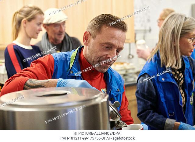 05 December 2018, Berlin: Thomas Hässler football coach of Berlin United and former national player (l) distributes hot drinks to the needy on the day of the...