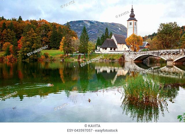 Church tower and stone bridge at Lake Bohinj in alpine village Ribicev Laz, Slovenia