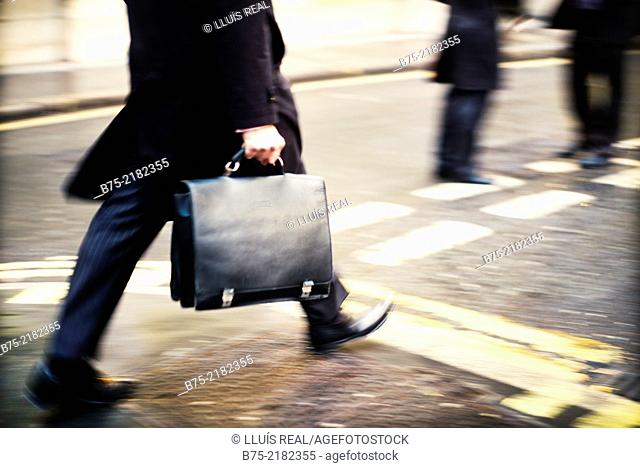 Legs of unrecognizable businessman with portfolio walking down in the street in the city of London, England, UK