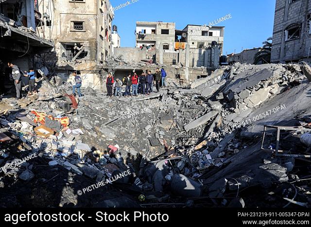 19 December 2023, Palestinian Territories, Rafah: Palestinians inspect the damage to a residential building belonging to the Zorob family following Israeli...