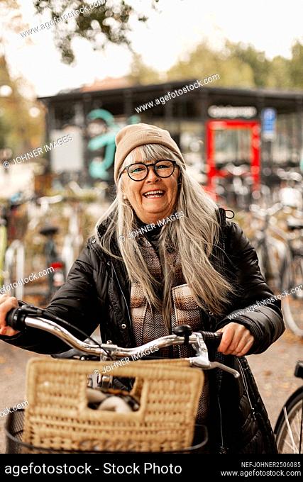 Happy woman holding bicycle