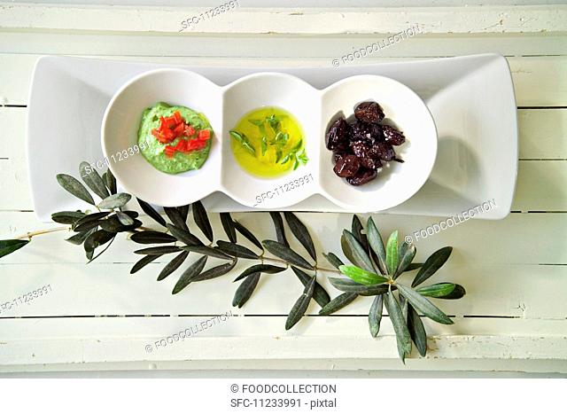 Green tahini, olive oil and black olives