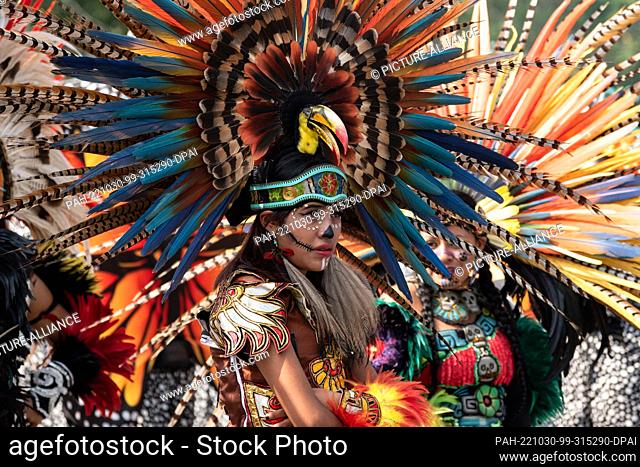 29 October 2022, Mexico, Mexiko-Stadt: A woman in Aztec costume is part of the indigenous peoples' parade at the Day of the Dead parade in Mexico City