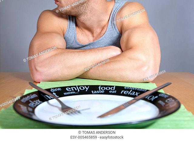 Muscular man with empty plate