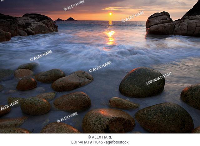 England, Cornwall, Porth Nanven. Sunset over the sea viewed from Porth Nanven, a beach sometimes referred to as 'Dinosaur Egg Beach' because of large deposit of...
