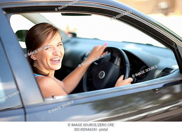 Teenage girl in braces driving car
