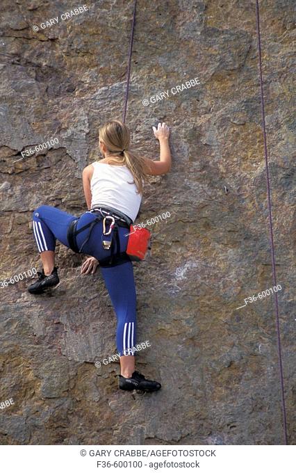 Female woman rock climber climbing cliff at Point Dume State Beach near Malibu, Los Angeles County, California
