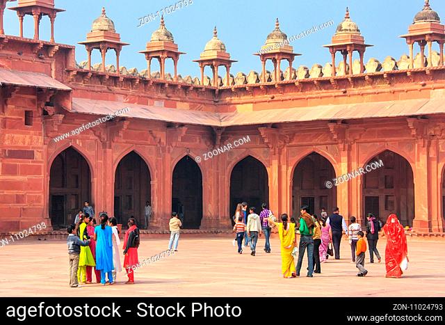 Tourists walking in the courtyard of Jama Masjid in Fatehpur Sikri, Uttar Pradesh, India. The mosque was built in 1648 by Emperor Shah Jahan and dedicated to...