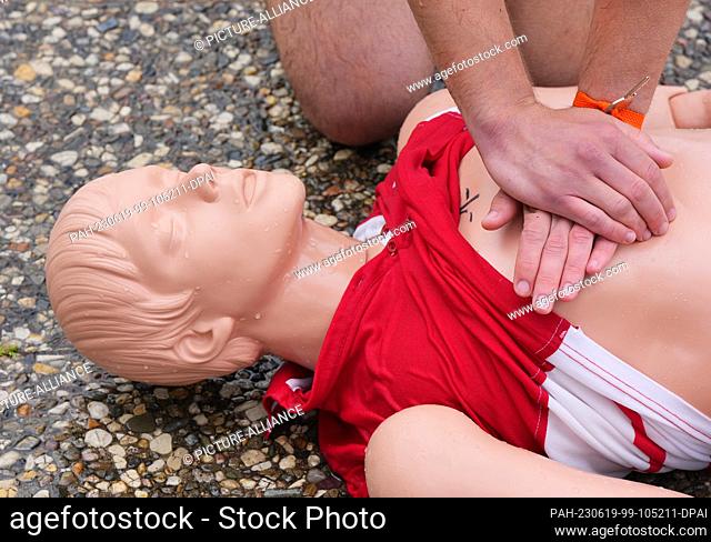 14 June 2023, Berlin: A young man demonstrates the methods of resuscitating a casualty on a manikin during the pre-swim of potential lifeguards at the...