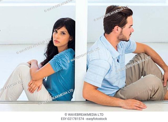 Sitting couple are separated by wall