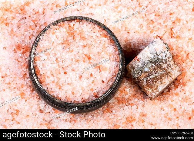 top view of old silver salt cellar, rough natural pink Halite mineral and grained Himalayan Salt close up