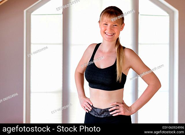 Happy young girl doing squat exercises at home